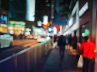 Abstract bokeh image of Hong Kong city street at night, with blurred lights and silhouettes.
