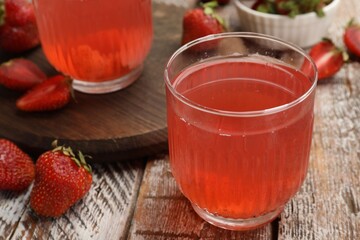 Tasty compot and strawberries on wooden table, closeup