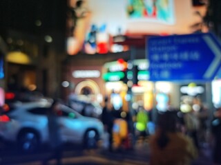 Abstract bokeh image of Hong Kong city street at night with blurred lights and signs.