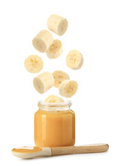 Baby food. Banana slices falling into jar of puree on white background