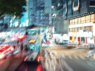 Abstract bokeh image of Hong Kong city street at night, with blurred lights and reflections.