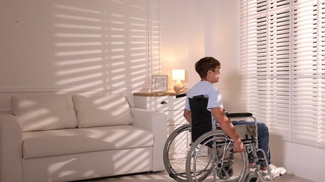 Teenage boy using wheelchair in light room
