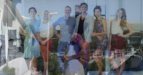 Posing six professionals in business casual smiling in conference area with glass wall and chairs