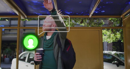 Man in hoodie raising arm waiting bus at gold-framed shelter, with coffee cup, icons, copy space