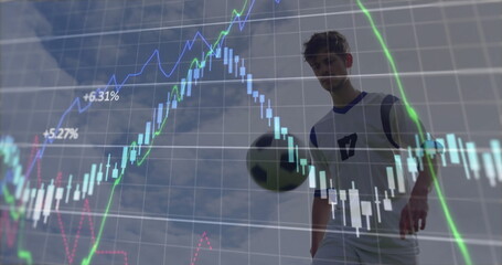 Male soccer player wearing blue jersey dribbling soccer ball against sky, with stock chart overlay