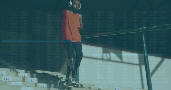 Stepping teenage athlete wearing orange top, prosthetic blade on bleachers, with phone, headphones