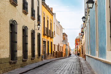 Cobblestone street with colonial buildings and view of the Cathedral of Queretaro, Mexico