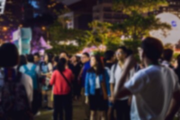 A blurred image of a group of people standing in front of a bokeh background.