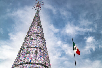 Illuminated Christmas tree and Mexican flag in public square of Santiago de Queretaro, Mexico