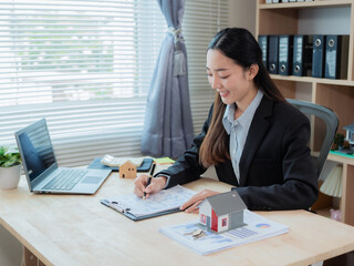 Asian woman home sales representative giving advice to clients after signing home purchase contract...