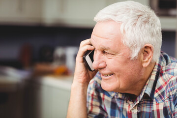 Smartphone ringing beside blurred kitchen countertop appliances during casual home call