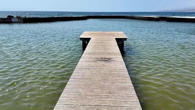 A peaceful wooden dock gracefully extending over calm, serene waters accompanied by a stunning sky backdrop