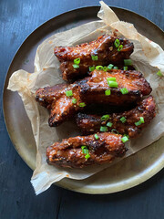 Glazed chicken wings with green onions.