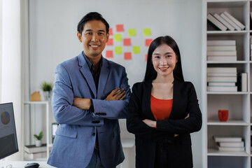 Happy Two Young Asian business couple working together, completing the assigned work
