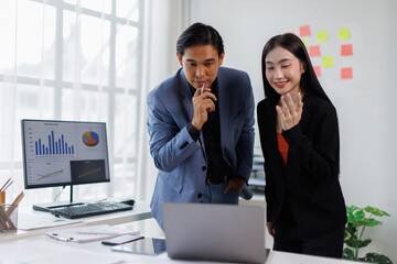Two Young Asian business couple working together, completing the assigned work
