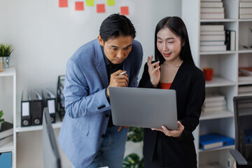 Two Young Asian business couple working together, completing the assigned work
