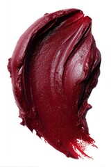 Fototapeta premium Close-up of a burgundy lip color swatch, showcasing its creamy texture and deep hue against a clean white backdrop, emphasizing its vibrant and luxurious appearance.
