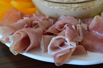Close-up of rolled slices of cured ham on a plate