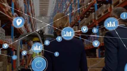 Businesswoman and businessman walking aisle, forklift moving pallet revealing supply chain overlays - Powered by Adobe