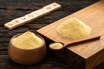 Coarse wheat semolina flour in a bowl and wooden spoon - Triticum