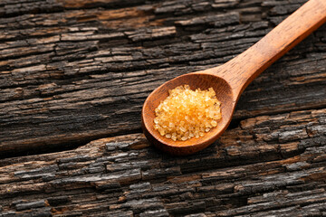 Saccharum officinarum - Organic brown sugar in a wooden spoon