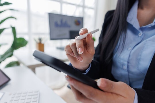Business asian woman working at office with tablet and document, doing planning analyzing the financial report, business plan investment, finance analysis concept. Economic business discussions.
