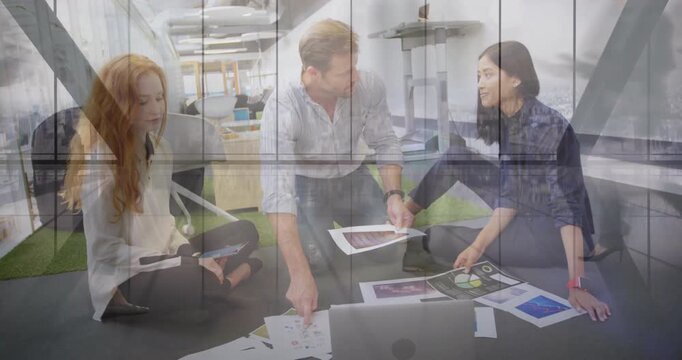Three colleagues pointing to mockups and comparing digital layouts while finalizing design proposal