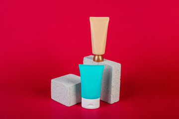 Cosmetic cream tube and skin care or sunscreen cosmetic with stylish propson red background.
