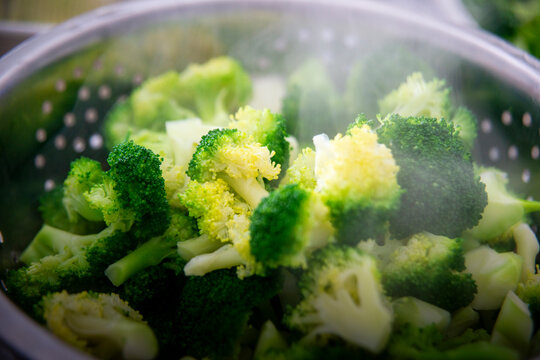 Freshly Steamed Broccoli in Metal Colander with Rising Steam &ndash; Healthy Cooking Concept