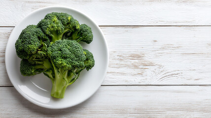 Fresh broccoli on white plate over rustic wooden background
