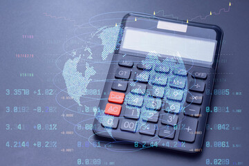 Calculator with a digital world map and stock data overlay. Technology concept global finance, trading analytics, and digital economy trends.