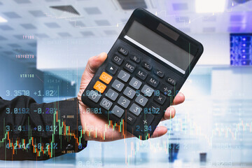 Professional holding digital calculator with financial trading charts and stock market data overlay. Business finance concept with investment analysis and economic planning visualization.