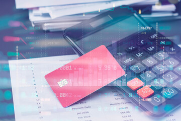 Red credit card, calculator and documents on a table in office with stock market data overlay. Technology concept personal finance, budgeting, online payments and accounting.