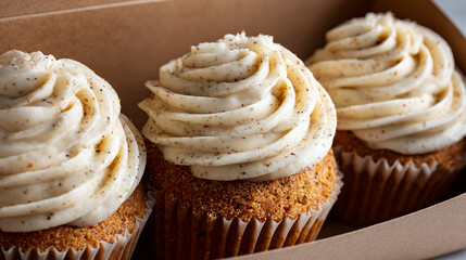 Three Gourmet Cupcakes With Vanilla Cream Frosting In Cardboard Box