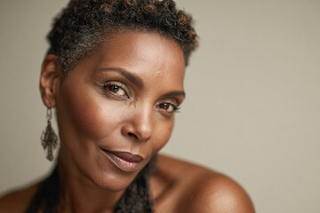 Confident middle-aged Black woman with short hair in studio portrait on white background
