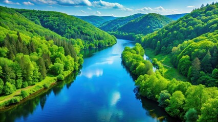 Naklejka premium Serene landscape with a vast blue river flowing through lush green hills and surrounded by towering trees