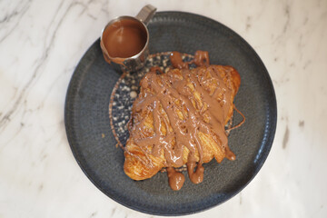 Croissant drizzled with chocolate sauce on a plate