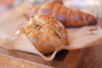 Freshly baked pastries on wooden tray in cozy cafe