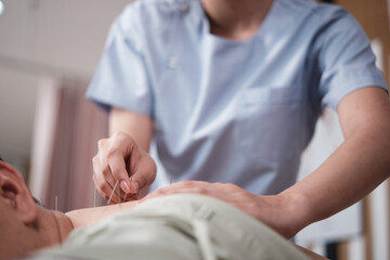 Close-up shot of Oriental healing, Asian physiotherapist treats patient's back muscle pain relief...