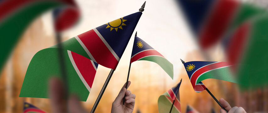 Namibia flags in their hands on a blurred urban background