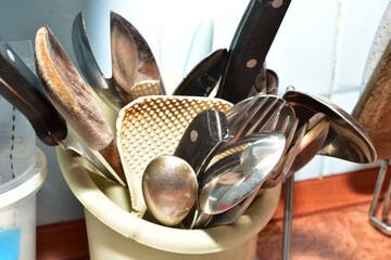 Close-up of spoons and forks stored in a special stand in the kitchen.