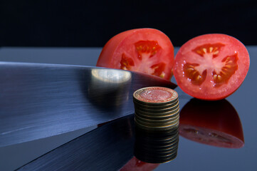 Freshly sliced red tomato in half with a kitchen knife and randomly surrounded by Mexican peso...