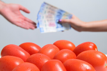 Closing negotiations and sales of fresh red tomatoes, and below against a blurred Person's hand...