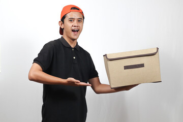 Excited Young Delivery Man Presenting Box with Open Palm Gesture