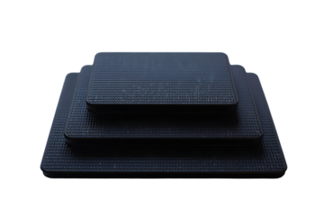 Three stacked black rectangular anti-slip mats with a distinctive grid texture and tiered design.
