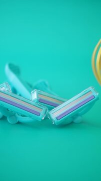 Colorful razors on a vibrant teal surface.