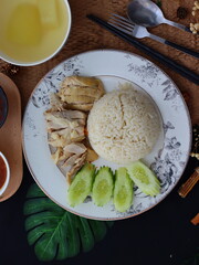 Khao Man Gai — Thai-style Hainanese chicken rice featuring tender boiled chicken served with aromatic chicken oil rice, rich soy-based dipping sauce, and fresh cucumber slices. A beloved Thai comfort 