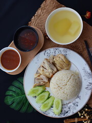 Khao Man Gai — Thai-style Hainanese chicken rice featuring tender boiled chicken served with aromatic chicken oil rice, rich soy-based dipping sauce, and fresh cucumber slices. A beloved Thai comfort 