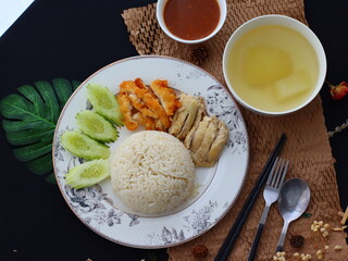 Khao Man Gai Tod — Thai-style crispy fried chicken served with fragrant chicken oil rice, accompanied by a savory dipping sauce and sliced cucumber. A popular street food dish in Thailand, combining j