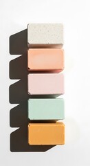 Stacked pastel colored soap bars with dramatic shadows